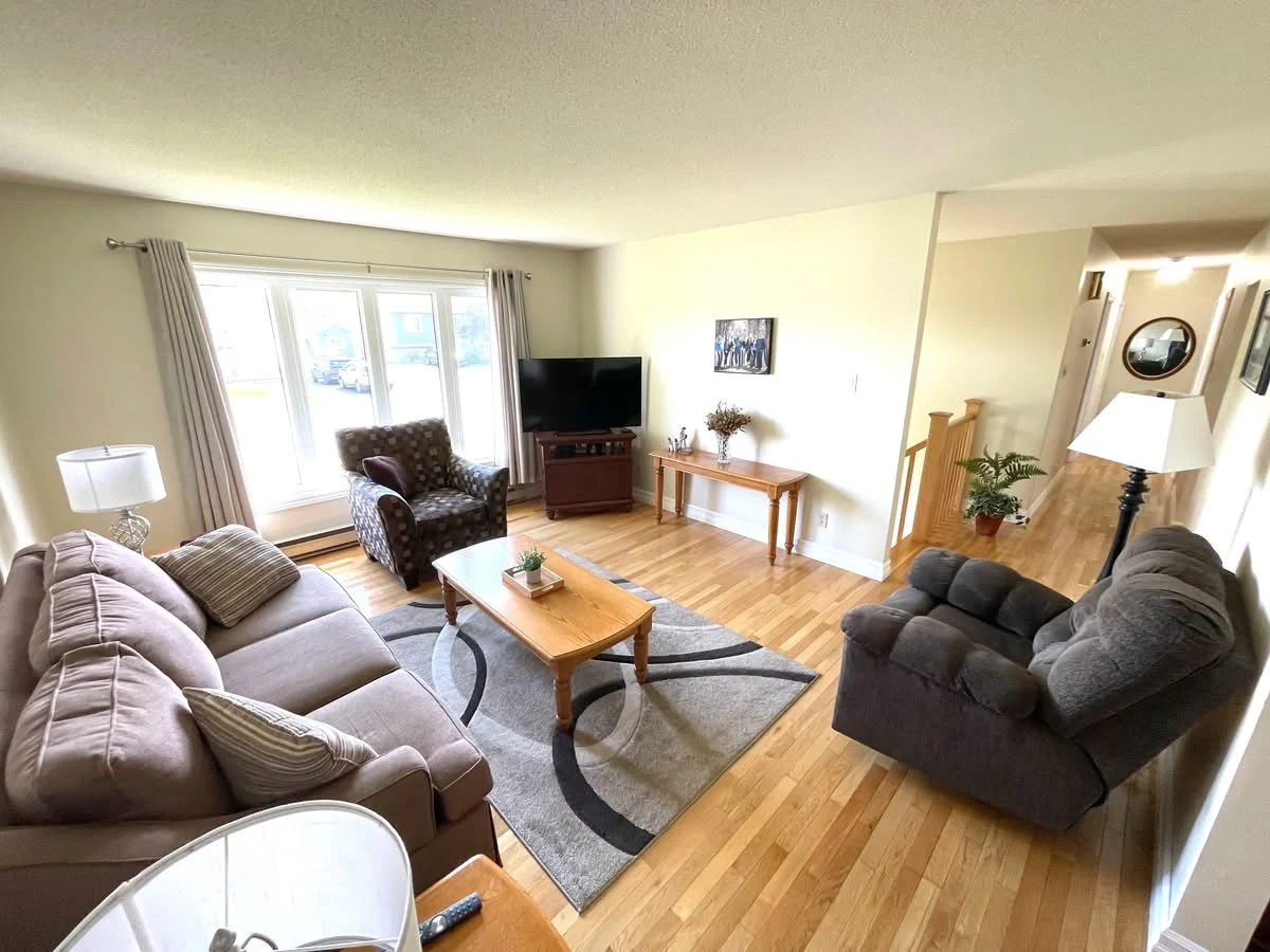 Bright living room with sofa, armchairs and a large window